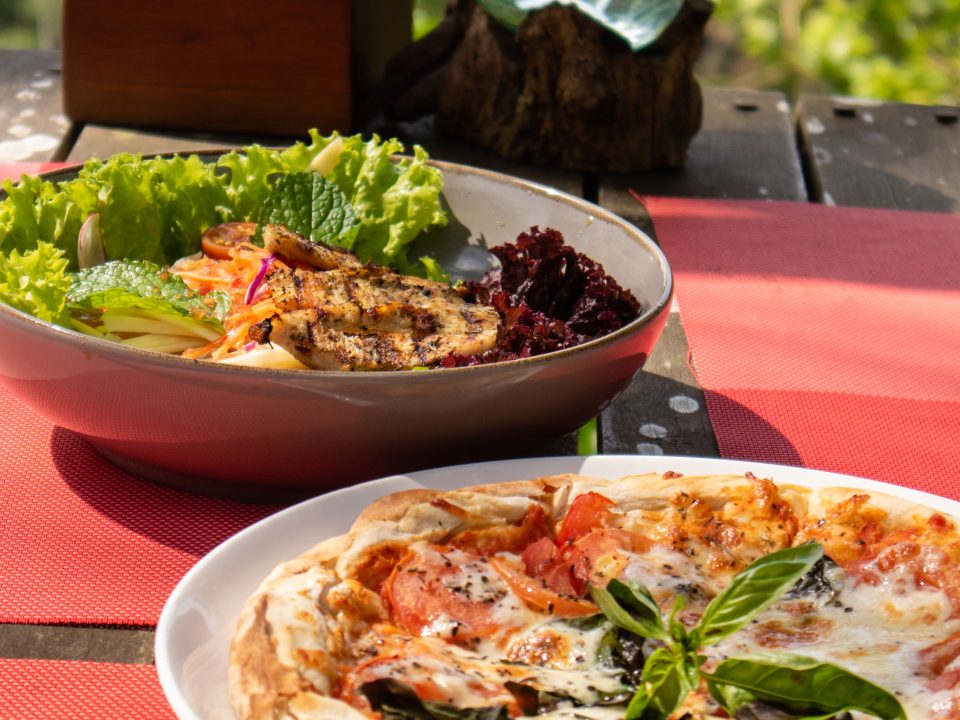 Hillside dining table overlooking lush jungle scenery.